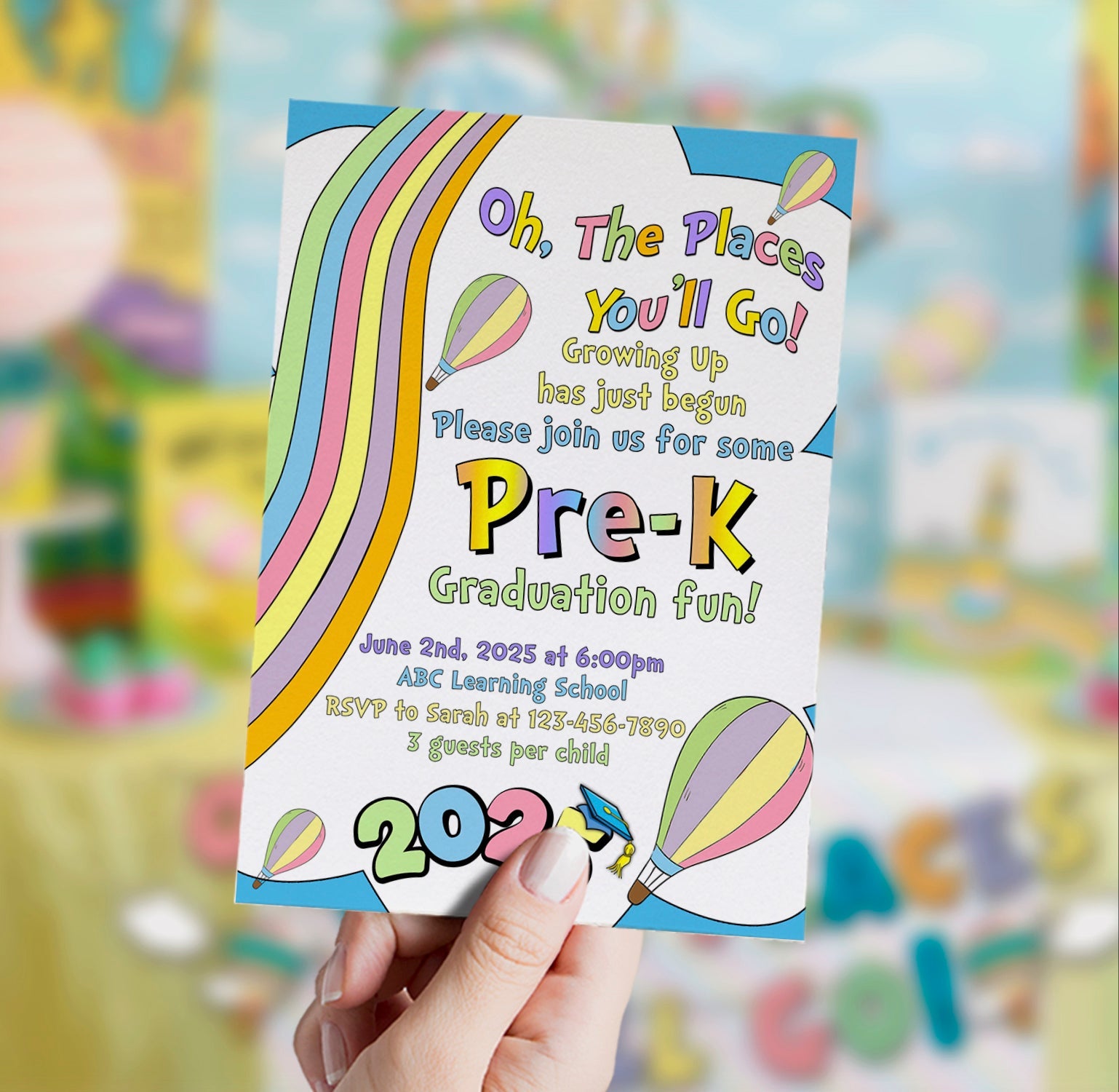Colorful pre-K graduation invitation held by a hand with blurred background